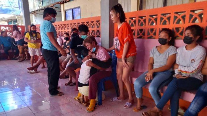 Martje Sumanti, nenek Aldo Merentek yang memakai kaos ungu saat memeluk ibu korban Welsye Mondoringin