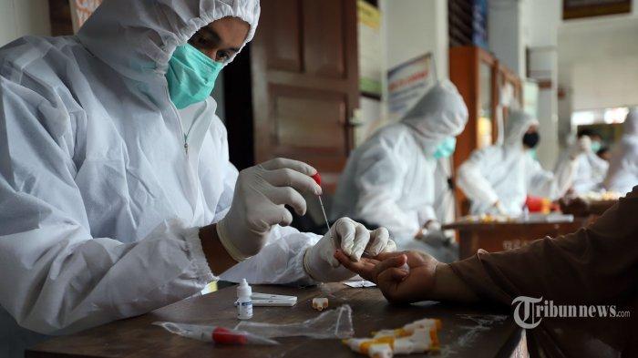 Petugas medis dari Polda Metro Jaya saat melakukan rapid test kepada sejumlah warga Petamburan di SDN 01 Petamburan, Jakarta Pusat, Minggu (22/11/2020).