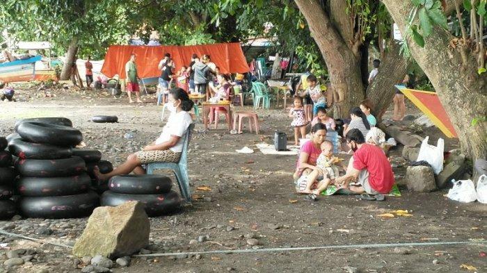 Puluhan warga berwisata di Pantai malalayang di saat weekend usai perayaan Idul Fitri, Minggu (16/5/2021). Libur panjang membuat warga antusias dalam mengunjungi objek-objek wisata.