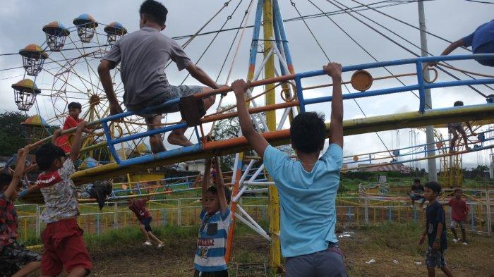 Sejumlah anak-anak bermain di salah satu wahana yang berada area pasar malam Boulevard Dua, Kota Manado, Sulawesi Utara, Rabu (22/12/2021).