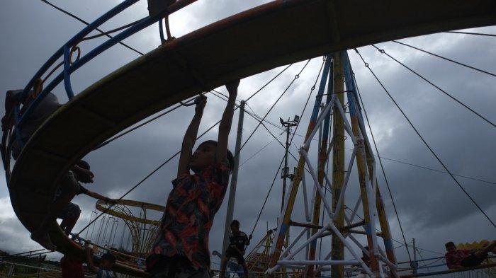 Sejumlah anak-anak bermain di salah satu wahana yang berada area pasar malam Boulevard Dua, Kota Manado, Sulawesi Utara, Rabu (22/12/2021).