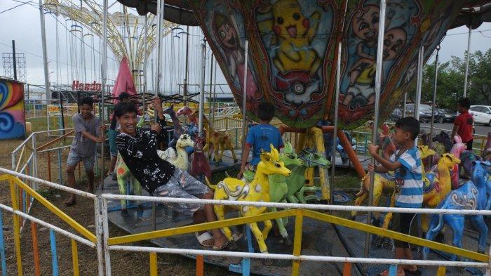 Sejumlah anak-anak bermain di salah satu wahana yang berada area pasar malam Boulevard Dua, Kota Manado, Sulawesi Utara, Rabu (22/12/2021).