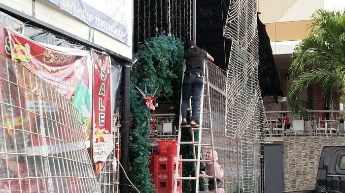 Sejumlah pertokoan yang menjual ornamen natal di pusat perbelanjaan Megamall Manado mulai berbenah pasca perayaan hari Natal di Sulawesi Utara, Senin (27/12/2021).