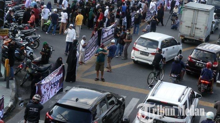 Sejumlah umat islam melakukan aksi serentak (Flash Mob) membentang spanduk di depan Masjid Raya, Medan, Rabu (16/11/2020). Aksi yang diikuti ratusan orang tersebut sebagai upaya gerakan kemanusiaan dan keadilan terhadap Habib Rizieq Shihab dan penembakan enam Laskar Front Pembela Islam (FPI).