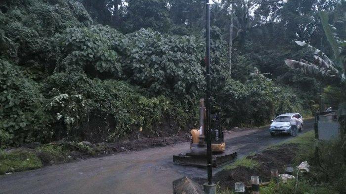 Seorang pekerja sedang memadatkan material pasir yang digunakan untuk memperbaiki jembatan Kembes yang hampir putus di Desa Kembes, Kecamatan Tombulu, Kabupaten Minahasa, Selasa (28/12/2021).