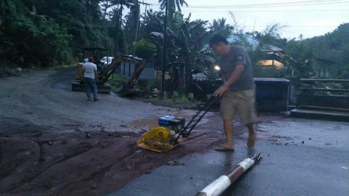Seorang pekerja sedang memadatkan material pasir yang digunakan untuk memperbaiki jembatan Kembes yang hampir putus di Desa Kembes, Kecamatan Tombulu, Kabupaten Minahasa, Selasa (28/12/2021).
