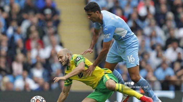 Striker Norwich City asal Finlandia Teemu Pukki (kiri) bersaing dengan gelandang Manchester City asal Spanyol Rodrigo (kanan) selama pertandingan sepak bola Liga Premier Inggris antara Manchester City dan Norwich City di Stadion Etihad di Manchester, barat laut Inggris, pada 21 Agustus 2021.