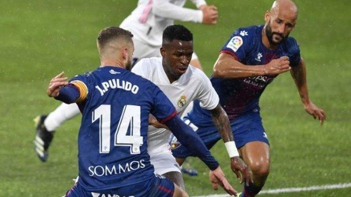 Penyerang muda Real Madrid, Vinicius Junior (tengah), mencoba melewati para pemain Huesca, Sabtu (6/2/2021) malam WIB di Stadion El Alcoraz.
