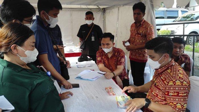 Warga antre menukar Uang Rupiah Tahun Emisi 2022 di Festival Basuara Digifest Pekan QRIS Nasional di Kawasan Megamas Manado, Jumat (19/08/2022).