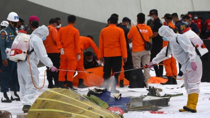 Petugas menyemprotkan cairan disinfektan ke bagian pesawat Sriwijaya Air SJ182 rute Jakarta - Pontianak yang jatuh di perairan Pulau Seribu di Dermaga JICT, Tanjung Priok, Jakarta Utara, Minggu (10/1/2021). Temuan bagian pesawat selanjutnya akan diperiksa oleh KNKT sedangkan potongan tubuh korban diserahkan kepada DVI Polri untuk identifikasi lebih lanjut.