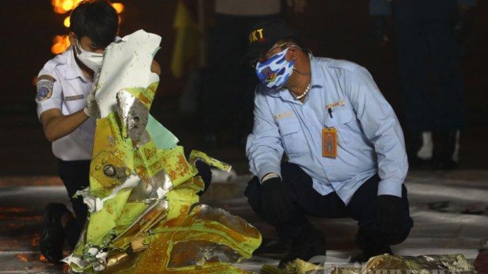 Anggota Komite Nasional Keselamatan Transportasi (KNKT) memeriksa bagian pesawat Sriwijaya Air SJ182 rute Jakarta - Pontianak yang jatuh di perairan Pulau Seribu di Dermaga JICT, Tanjung Priok, Jakarta Utara, Minggu (10/1/2021). Temuan bagian pesawat selanjutnya akan diperiksa oleh KNKT sedangkan potongan tubuh korban diserahkan kepada DVI Polri untuk identifikasi lebih lanjut.