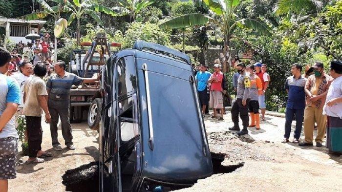 Mobil Kijang terperosok ke dalam lubang di Jalan Kaliwiro Wonosobo, Selasa (16/2/2021).