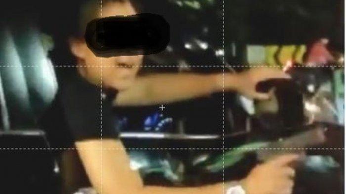 Tangkapan layar video pengendara mobil Fortuner mengacungkan senjata ke pengendara lain di kawasan Duren Sawit, Jakarta Pusat, Jumat (2/4/2021).
