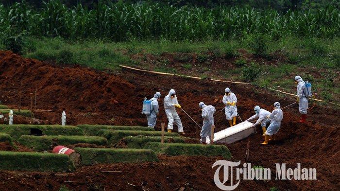 Sejumlah petugas menggunakan alat pelindung diri (APD) melakukan proses pemakaman jenazah, di TPU Khusus Covid-19 Simalingkar, Medan, Kamis (5/8/2021). Total sebanyak 1581 jenazah yang telah dimakamkan di TPU Khusus Covid-19 Simalingkar tersebut sejak tahun 2020.