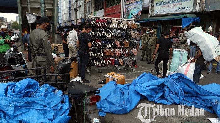 Petugas Satpol PP menertibkan pedagang kaki lima (PKL) yang berdagang di pedestrian di Jalan Gatot Subroto, Medan, Kamis (18/2/2021). Selain menertibkan, petugas juga menyosialisasikan warga agar tetap mematuhi protokol kesehatan ditengah pandemi Covid-19.