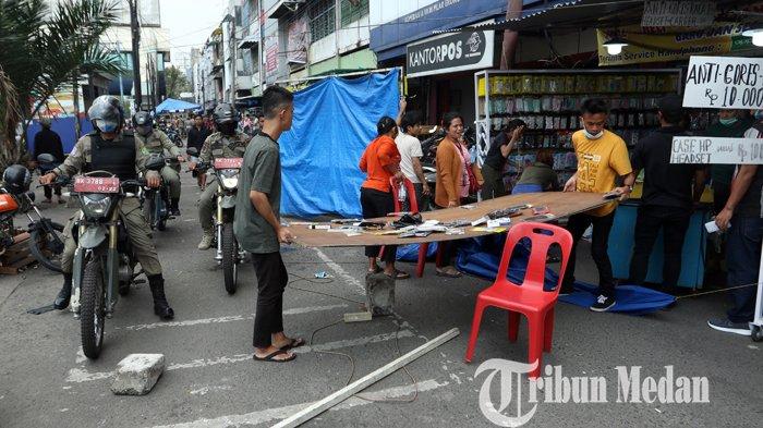 Petugas Satpol PP menertibkan pedagang kaki lima (PKL) yang berdagang di pedestrian di Jalan Gatot Subroto, Medan, Kamis (18/2/2021). Selain menertibkan, petugas juga menyosialisasikan warga agar tetap mematuhi protokol kesehatan ditengah pandemi Covid-19.