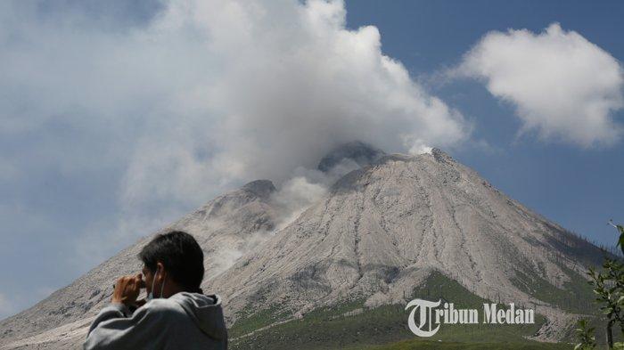 Asap sulfatara mengepul disertai guguran material vulkanik dari puncak Gunung Sinabung dari Desa Sigarang-garang, Kecamatan Namanteran, Karo, Sumatera Utara, Sabtu (21/2/2021).TRIBUN MEDAN/RISKI CAHYADI