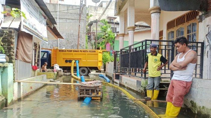 PETUGAS Dinas PU kota Medan saat menunggu penyedotan genangan air di Gang Subur Lama, Jalan Brigjen Katamso, Kampung Baru, Kecamatan Medan Maimun, Kamis (21/1/2021).