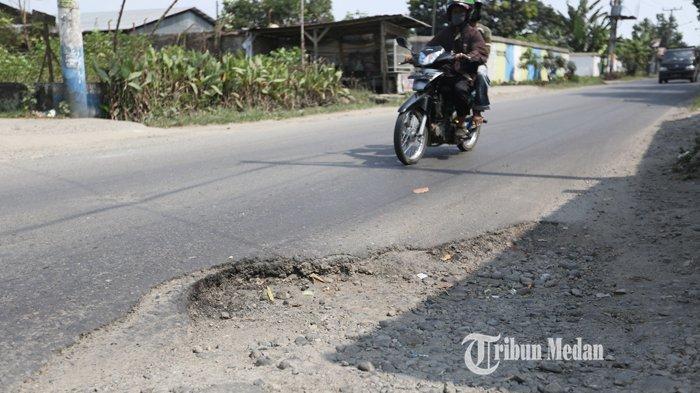 Kendaraan melintas di ruas jalan rusak, di Jalan Pertahanan, Desa Sigara-Gara, Patumbak, Deliserdang, Sumatera Utara, Selasa (16/3/2021). Jalan yang kondisinya rusak parah dan sering makan korban tersebut sudah lebih dari satu tahun dibiarkan tanpa perbaikan.TRIBUN MEDAN/RISKI CAHYADI