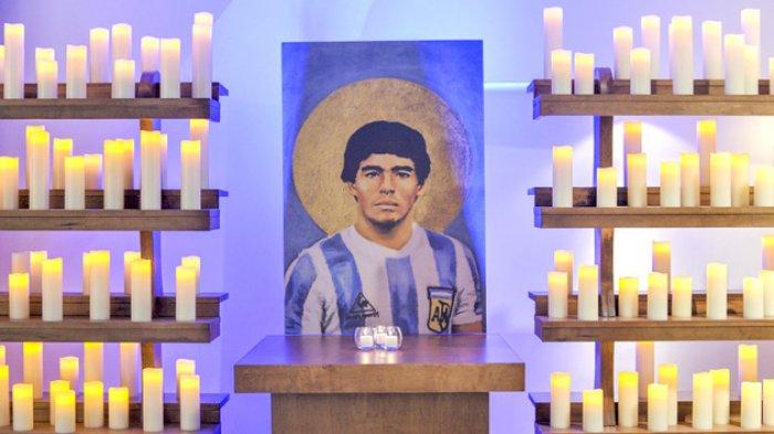 Lilin dinyalakan di sisi lukisan Diego Maradona di gereja pemujaan untuk dirinya di Kota Buenos Aires, Argentina.