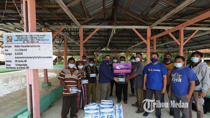 Territory Sales Manager XL Axiata area Karo-Langkat, Maf’ul Taufiq memberikan masker kepada warga Desa Tigapancur, Kecamatan Simpangempat, Karo, Sabtu (20/2).TRIBUN MEDAN/RISKI CAHYADI