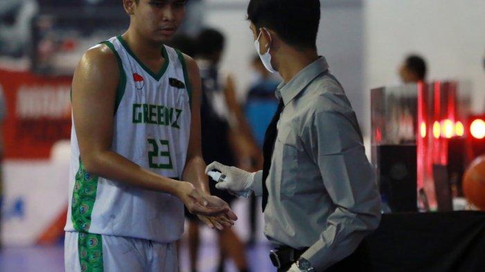 Ofisial tim SMAN 2 Mataram menyemprotkan hand sanitizer kepada salah satu pemainnya