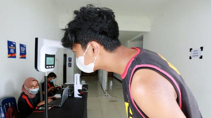 PATUH PROKES: Pemain SMAN 1 Mataram, Ida Bagus Aditya Nugraha melakukan cek suhu tubuh sebelum memasuki area venue