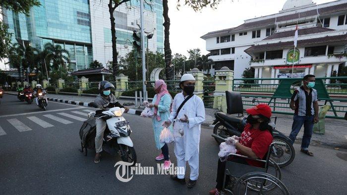 Penyandang disabilitas membagikan takjil kepada pengguna jalan di depan kantor Wali Kota Medan, Jalan Kapten Maulana Lubis, Medan, Sumatera Utara, Selasa (20/4/2021). Kegiatan tersebut untuk mengurangi stigma negatif penyadang disabilitas serta sebagai bentuk kepedulian terhadap pengendara khususnya umat Muslim yang sedang menjalankan ibadah puasa di bulan Ramadan 1442 H.TRIBUN MEDAN/RISKI CAHYADI