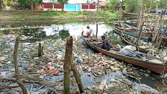 Nelayan yang sedang menyusun perahu di bawah jembatan yang melintasi Sungai Bederah, Jalan Kapten Rahmad Buddin, Kelurahan Terjun, Kecamatan Medan Marelan, Kamis (24/3/2021). Sungai yang kotor membuat nelayan bertahun-tahun kesulitan mencari nafkah.(TRIBUNMEDAN/RECHTIN)