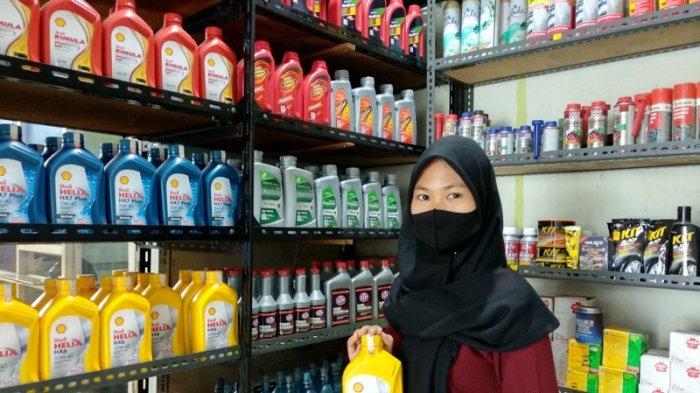 KARYAWAN Valentino Auto Service sedang melakukan pengecekan stok oli di bengkel.