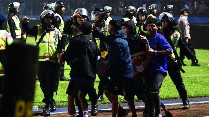 Aremania membopong korban kericuhan saat laga Arema FC vs Persebaya Surabaya di Stadion Kanjuruhan, Kabupaten Malang, Sabtu (1/10/2022).