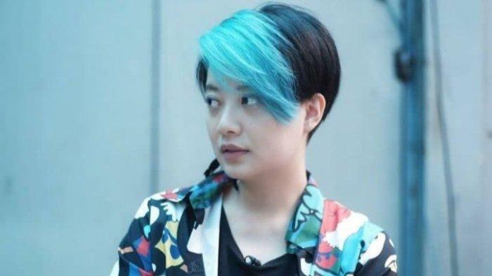 Foto Leony masa kini yang swag dengan gaya maskulin dengan rambut birunya.