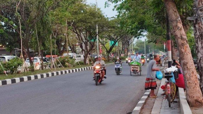 Para pemulung menunggu donatur memberikan nasi bungkus atau uang di Jalan arteri Soekarno-Hatta, Pedurungan, Kota Semarang.