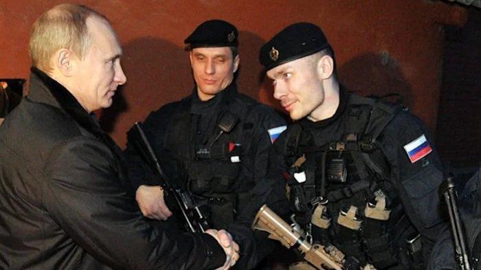 Presiden Rusia Vladimir Putin berjabat tangan dengan petugas FSB selama kunjungan ke kota terbesar kedua di Chechnya, Gudermes, pada 20 Desember 2011.