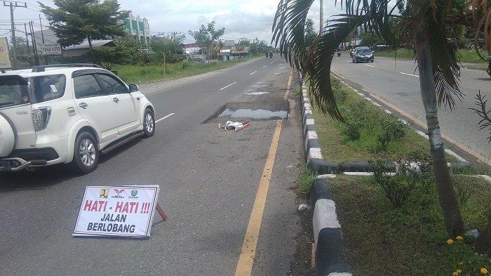 Kondisi jalan bekas galian di Km 13 By Pass, Kota Padang dilewati mobil berada di seberang Rumah Sakit Gigi dan Mulut Baiturahmah Padang - dekat simpang Sungai Sapih -- arah Jalan By Pass Ketaping. Foto diabadikan pada Minggu (28/03/2021).