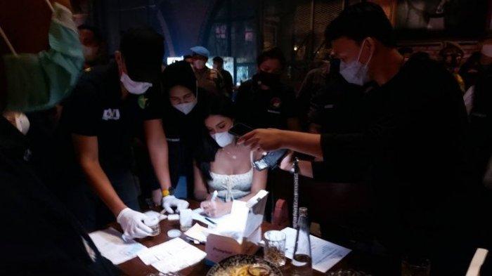 Selebgram Millen Cyrus (tengah) jalani tes urine saat terjaring razia protokol kesehatan yang dilaksanakan oleh Direktorat Reserse Narkoba Polda Metro Jaya di Bar Brotherhood Gunawarman, Kebayoran Baru, Jakarta Selatan, Minggu dini hari (28/2/2021).