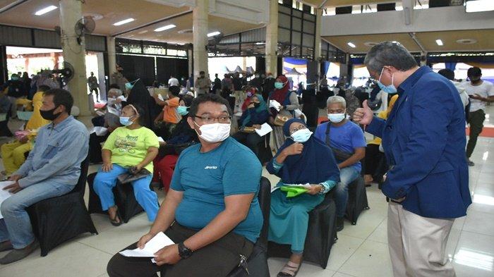 Direktur Keuangan dan Umum PT Pusri Palembang Saifullah Lasindrang sedang bercakap sama peserta vaksin, ibu-ibu yang antrian menunggu giliran di suntik vaksin di Gedung Serba Guna Komplek PT Pusri Palembang menerapkan protokol kesehatan yang ketat (25/11/2021).