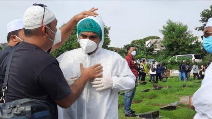 Teddy Syach saat memakai APD untuk ikut memakamkan istrinya, Rina Gunawan di TPU Tanah Kusir Jakarta Selatan, Selasa (3/3/2021).