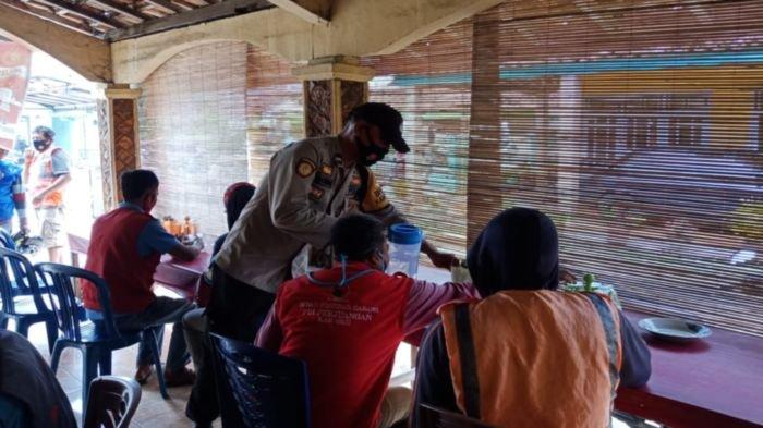 Warga menekmati nasi bungkus dalam kegiatan Warung Mang PeDeKa Polsek Baturaja Timur berbagi makan gratis.