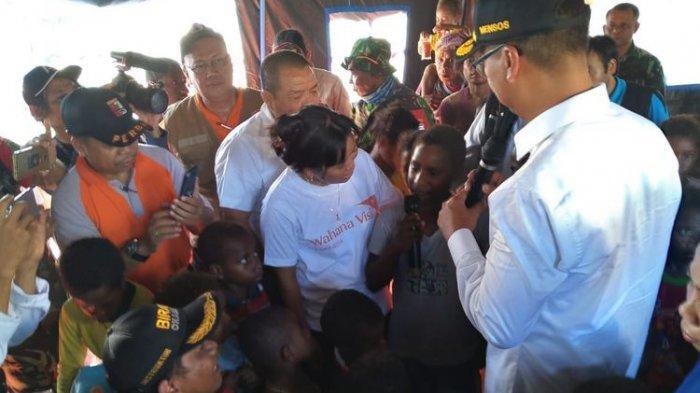 Menteri Sosial Agus Gumiwang Kartasasmita (mengenakan topi) sedang mendengar harapan dari Rini Enundi, salah satu anak-anak yang terdampak banjir bandang yang sedang mengungsi di Stadion Barnabas Youwe, Kabupaten Jayapura, Papua, Rabu (27/3/2019).