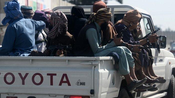 Pasukan Taliban sedang berpatroli di atas kendaraan.