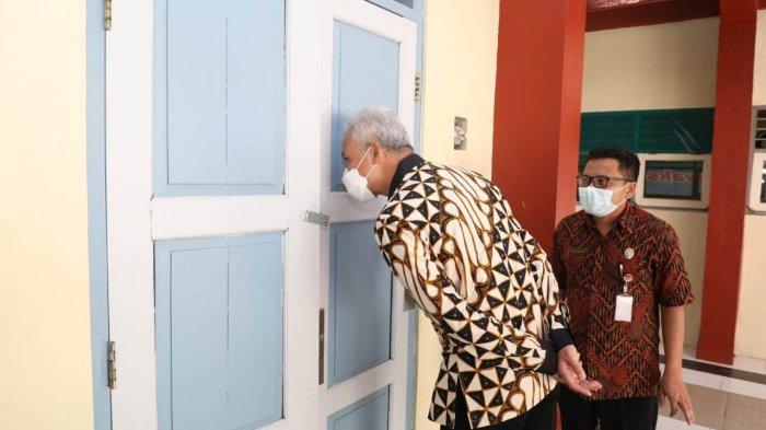 Gubernur Jawa Tengah, Ganjar Pranowo, mengintip ruang kelas saat meninjau pelaksanaan PTM di SMKN 1 Tengaran, Kabupaten Semarang, Jumat (24/9/2021).