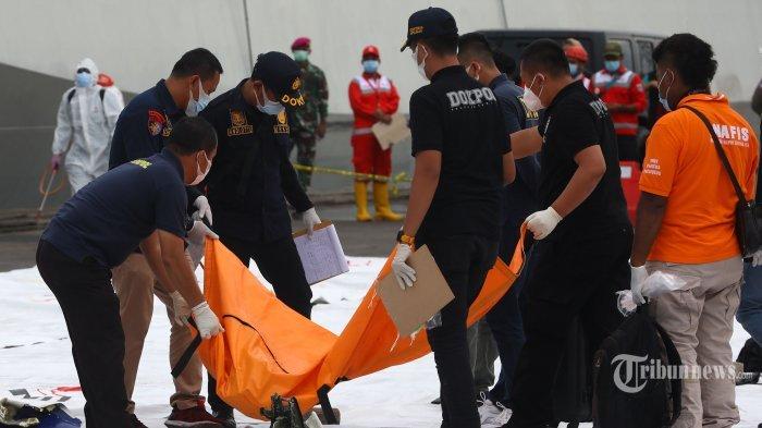 Petugas mengidentifikasi kantong jenazah korban jatuhnya pesawat Sriwijaya Air SJ182 rute Jakarta - Pontianak yang jatuh di perairan Pulau Seribu di Dermaga JICT, Tanjung Priok, Jakarta Utara, Minggu (10/1/2021). Temuan bagian pesawat selanjutnya akan diperiksa oleh KNKT sedangkan potongan tubuh korban diserahkan kepada DVI Polri untuk identifikasi lebih lanjut.