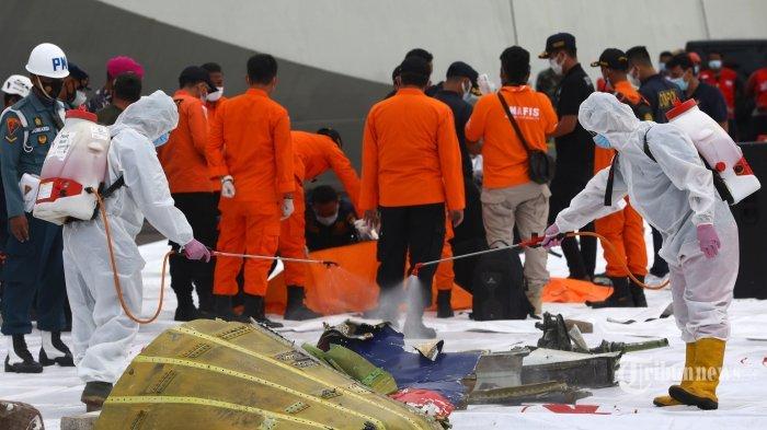 Petugas menyemprotkan cairan disinfektan ke serpihan pesawat Sriwijaya Air SJ182 rute Jakarta - Pontianak yang jatuh di perairan Pulau Seribu di Dermaga JICT, Tanjung Priok, Jakarta Utara, Minggu (10/1/2021). Temuan bagian pesawat selanjutnya akan diperiksa oleh KNKT sedangkan potongan tubuh korban diserahkan kepada DVI Polri untuk identifikasi lebih lanjut.