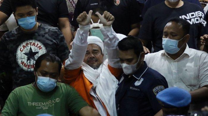 Pimpinan FPI Muhammad Rizieq Shihab menuju mobil tahanan setelah menjalani pemeriksaan di Polda Metro Jaya, Minggu (13/12/2020). Rizieq Shihab diperiksa sebagai tersangka kasus kerumunan di Petamburan.