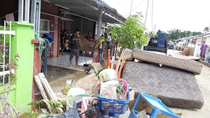 Penghuni Perumahan Pesona Harapan Indah, Jalan Cengkeh, Kota Pekanbaru tampak bersih-bersih, Minggu (25/4/2021) pasca banjir melanda selama hampir empat hari.