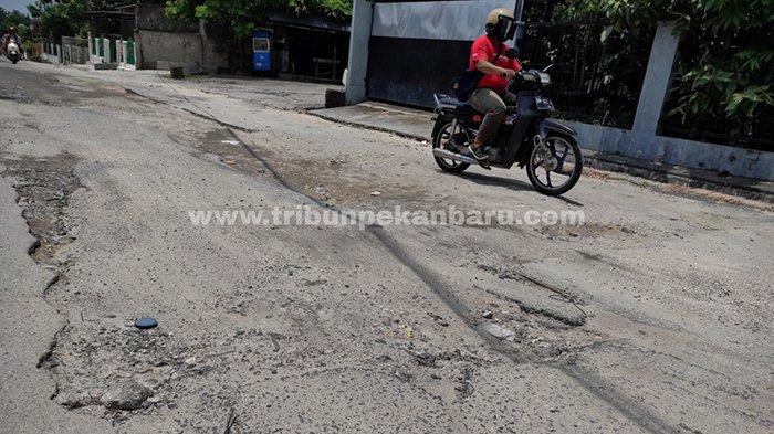 Kendaraan melintas di bekas galian perpipaan limbah rumah tangga di Jalan Melati, Kecamatan Sukajadi, Pekanbaru yang rusak, Selasa (13/4/2021).
