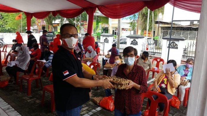 Anggota DPRD Pekanbaru Robin Eduar SH MH (kiri) menyerahkan bantuan sembako kepada warga, saat acara Sosialisasi Perda akhir pekan lalu di Jalan Pemuda Gg Mesjid Kecamatan Payung Sekaki.