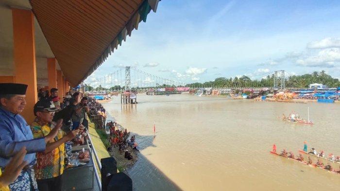 Dari Tepian Narosa Bupati Siak Alfedri ikut melambaikan tangan ke peserta pacu jalur, Minggu (21/8/2022).