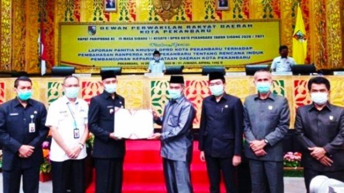 Ketua DPRD Pekanbaru Hamdani SIP (kanan) menyerahkan draf Perda Rippda Pekanbaru kepada Wakil Walikota Pekanbaru Ayat Cahyadi di dampingi Wakil Ketua DPRD Ir Nofrizal MM, saat Rapat Paripurna awal pekan kemarin.